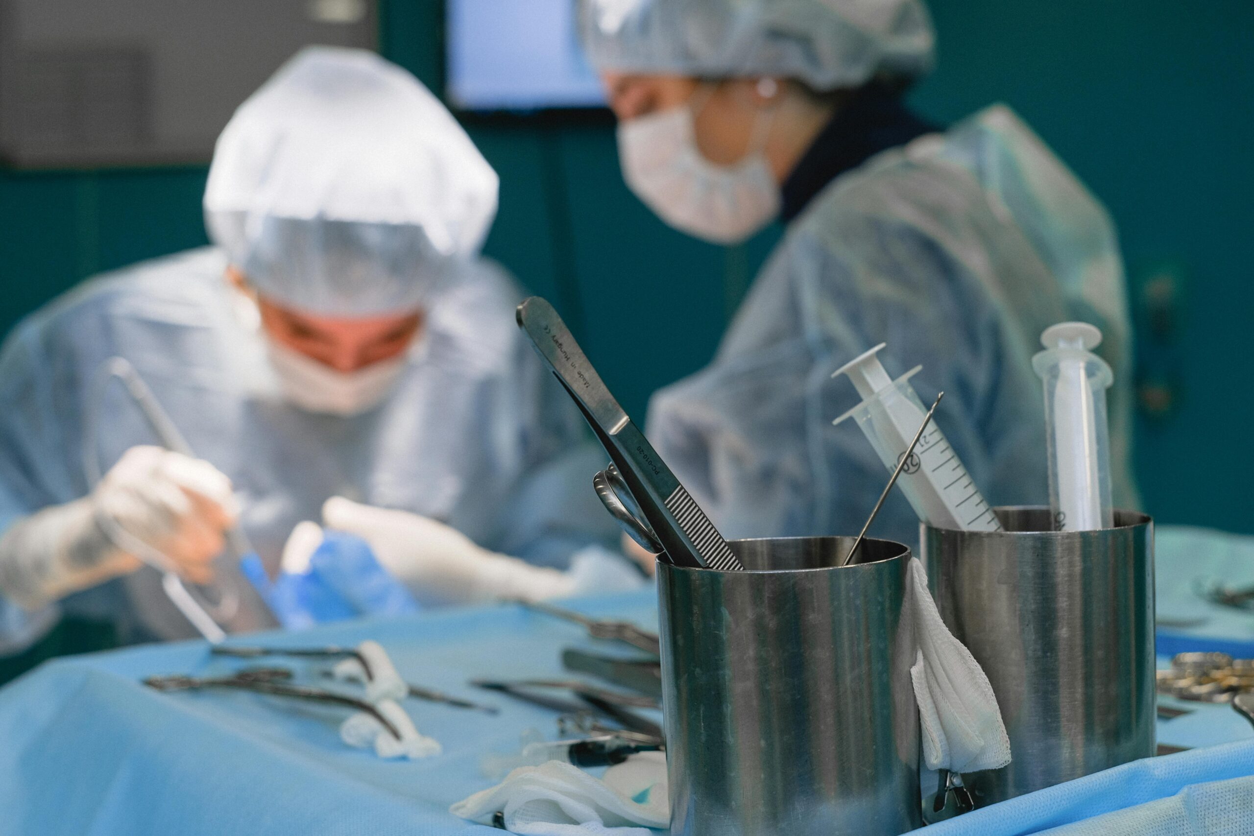 Focused surgeons in an operating room performing surgery with medical instruments.